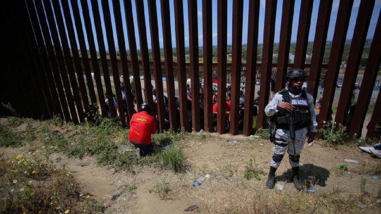 Migrantes se reúnen a lo largo de la frontera entre Estados Unidos y México.