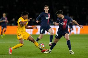 Barcelona's Lamine Yamal, left, is challenged by PSG's Lucas Beraldo during the Champions League quarterfinal first leg soccer match between Paris Saint-Germain and Barcelona at the Parc des Princes stadium in Paris, Wednesday, April 10, 2024. (AP Photo/Lewis Joly)