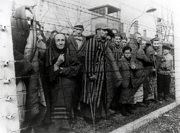 Survivors of Auschwitz behind a barbed wire fence, Poland, February 1945. Photo taken by a Russian photographer during the making of a film about the liberation of the camp. The children were dressed up by the Russians with clothing from adult prisoners. (Photo by Galerie Bilderwelt/Getty Images)
