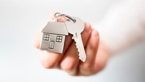Sosteniendo las llaves de la casa en el concepto de llavero en forma de casa para comprar una casa nueva