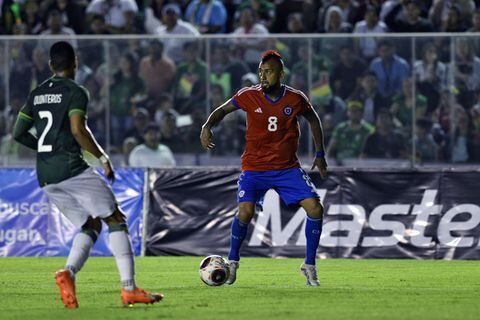 El defensor boliviano Jairo Quinteros (L) y el mediocampista chileno Arturo Vidal luchan por el balón durante el partido amistoso de fútbol entre Bolivia y Chile, en el estadio Ramón Tahuichi Aguilera en Santa Cruz, Bolivia, el 20 de junio de 2023. (Foto de AIZAR RALDES / AFP)