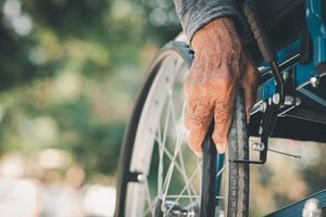 close-up  of hand senior man pushing wheelchair
