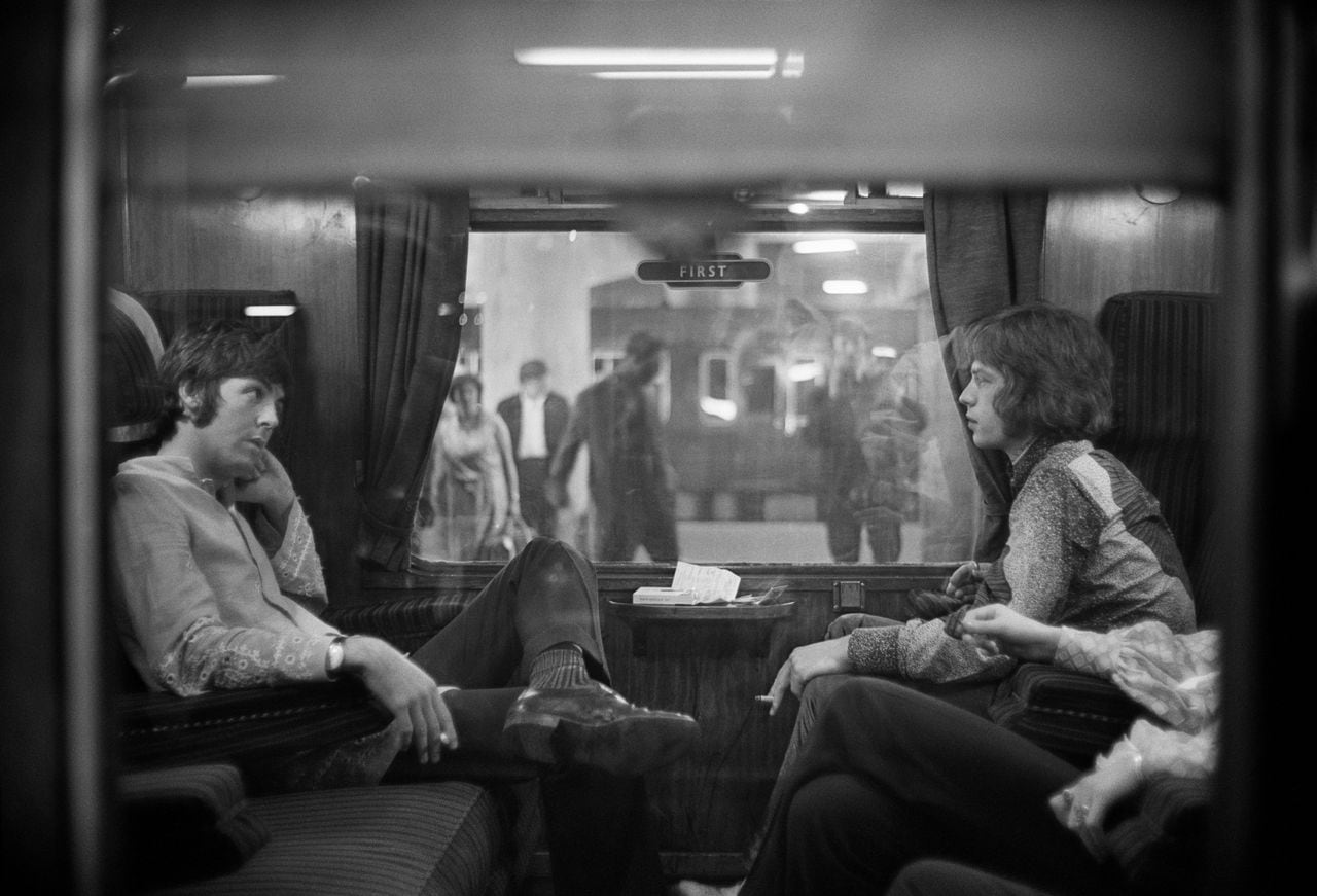 25th August 1967:  Paul McCartney of the Beatles and Mick Jagger of the Rolling Stones sit opposite each other on a train at Euston Station, waiting for departure to Bangor.  (Photo by Victor Blackman/Express/Getty Images)