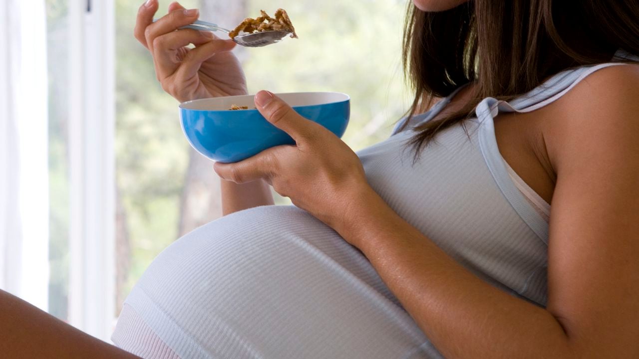 Mujer embarazada desayunando