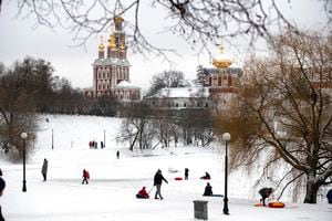 People with children enjoy sledding in Moscow's Novodevichy Park, Russia, Tuesday, Jan. 5, 2021. (AP Photo/Pavel Golovkin)