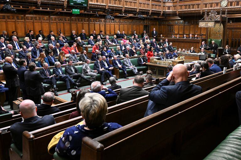 El primer ministro británico, Rishi Sunak, y el ministro británico de Inmigración, Robert Jenrick, escuchan mientras la ministra del Interior británica, Suella Braverman, habla durante la declaración del proyecto de ley de migración ilegal en la Cámara de los Comunes