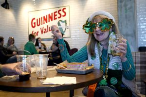 Eileen Cavanagh is decked out in St. Patrick's Day gear as she converses with her husband, Emmet Cavanagh, while dining at the Guinness Open Gate Brewery, Saturday, March 13, 2021, in Halethorpe, Md. The brewery is engaging in its "17 Days of St. Patrick's Day" events while following social distancing to prevent the spread of Covid-19. Officials are asking people to stay vigilant in hopes to not spreading the coronavirus during the holiday, including Baltimore City Liquor License Commissioners, who says there will be increased monitoring for COVID-19 regulations and that pub crawls are prohibited. (AP Photo/Julio Cortez)