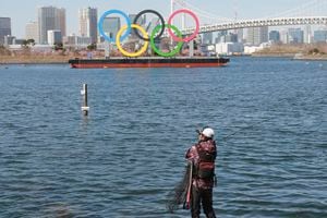 Un pescador disfruta pescar con los anillos olímpicos flotando en el agua en Tokio. Foto: AP / Koji Sasahara.