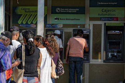 Varias personas hacen fila para retirar dinero de cajeros automáticos en un banco de La Habana el 3 de agosto de 2023.