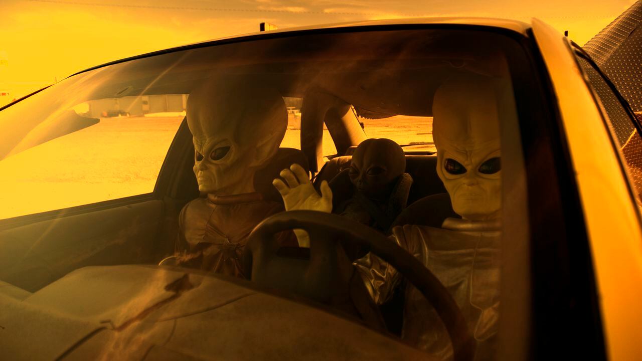 Ilustración de extraterrestres conduciendo un carro.