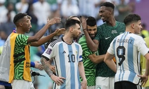 Argentina's Lionel Messi standing beside Saudi Arabia's players celebrating after winning the World Cup group C soccer match between Argentina and Saudi Arabia at the Lusail Stadium in Lusail, Qatar, Tuesday, Nov. 22, 2022. (AP Photo/Natacha Pisarenko)