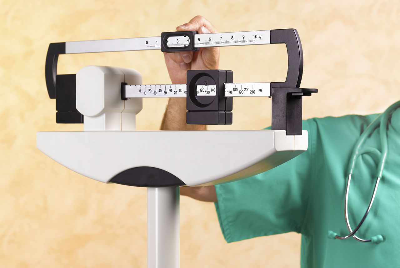 Brazo de médicos en escalas médicas con sobrepeso