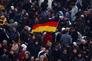 Un fiel sostiene una bandera de Alemania mientras la gente se reúne en la Plaza de San Pedro el día del funeral del ex Papa Benedicto en el Vaticano. REUTERS/Guglielmo Mangiapane