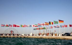 Una vista general muestra las banderas de los países clasificados para la Copa del Mundo de 2022 en la capital de Qatar, Doha, durante una ceremonia de izamiento de la bandera de los últimos países restantes en clasificar, el 16 de junio de 2022. (Foto de Mustafa ABUMUNES / AFP)