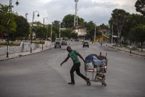 Un hombre tira de un carrito de compras cargado por una calle, vacía debido a una huelga general en Puerto Príncipe, Haití. Foto AP / Joseph Odelyn.