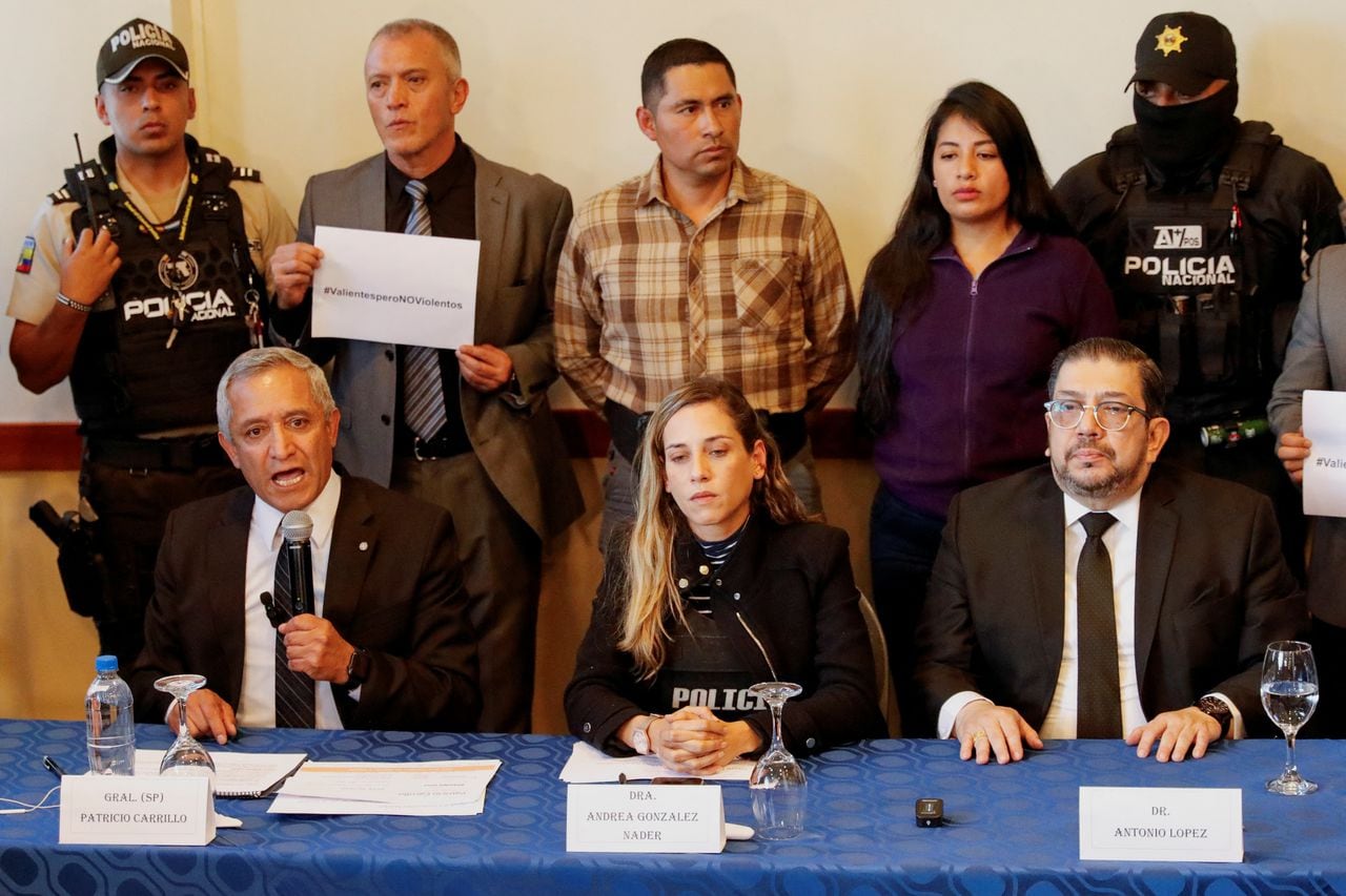 Andrea Gonzalez, vice-presidential running mate of Ecuadorean presidential candidate Fernando Villavicencio, a vocal critic of corruption and organized crime who was killed during a campaign event, attends a press conference on behalf of the campaign while wearing a bulletproof vest, next to Patricio Carrillo, former Ecuadorean defence minister and current candidate for the National Assembly, and campaign manager Antonio Lopez, as a man displays a placard that reads: "Brave but not violent", in Quito, Ecuador, August 10, 2023. REUTERS/Karen Toro