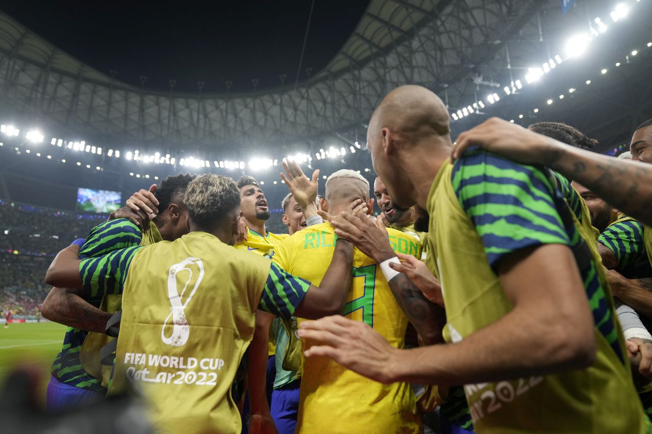 Brazil's Richarlison, center with back to camera, is congratulated by his teammates after scoring the opening goal during the World Cup group G soccer match between Brazil and Serbia, at the Lusail Stadium in Lusail, Qatar, Thursday, Nov. 24, 2022. (AP Photo/Andre Penner)