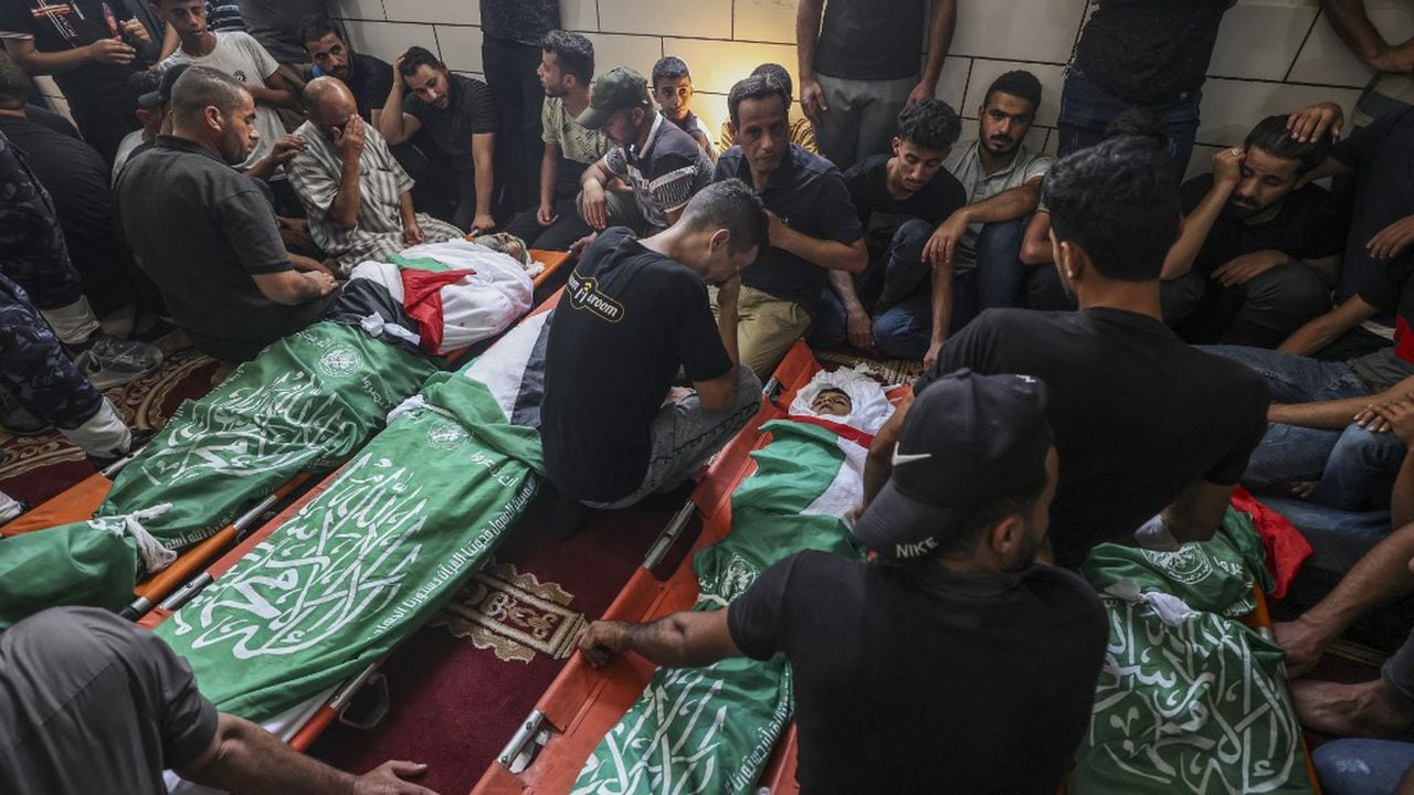 Los palestinos lloran junto a los cuerpos de los miembros de la familia al-Nabahin durante su funeral en el campo de refugiados de al-Bureij en el centro de la Franja de Gaza, el 8 de agosto de 2022, luego de que fueran asesinados durante los últimos tres días de conflicto entre Israel y militantes palestinos, antes de un alto el fuego. (Foto de Mahmud JAMONES / AFP)