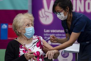 Una anciana recibe la vacuna CoronaVac para COVID-19 desarrollada por la compañía biofarmacéutica china Sinovac Biotech, en una clínica en Santiago, Chile, el miércoles 3 de febrero de 2021.  (AP Foto/Esteban Felix)