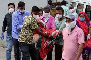 Familiares llevan a una mujer que se desmayó después de ver el cuerpo de su esposo en un hospital gubernamental COVID-19 en Ahmedabad, India, el martes 27 de abril de 2021. Los casos de coronavirus en India están aumentando más rápido que en cualquier otro lugar del mundo. Foto: AP / Ajit Solanki.
