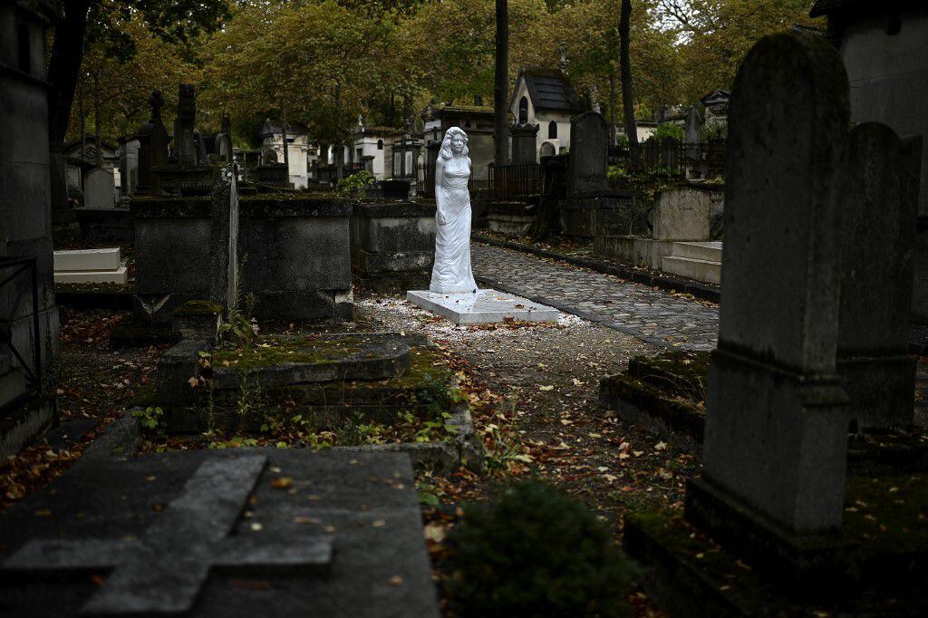 This picture shows the life-size statue of an unidentified woman adorning an empty grave at the Pere Lachaise cemetery in Paris on September 25, 2020. - The sculpture of a woman, an empty grave, an anonymous backer and a hint of megalomania: a Carrara marble statue of woman appeared in the middle of July in an alley of the Parisian cemetery of Pere Lachaise. (Photo by Christophe ARCHAMBAULT / AFP)