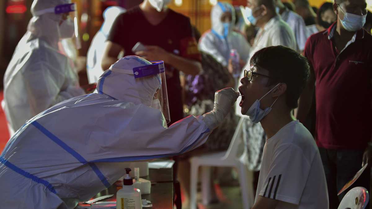 En esta foto publicada por la Agencia de Noticias Xinhua, un trabajador de la salud toma una muestra de hisopo de un residente durante una prueba masiva de COVID-19 en Putian, en la provincia de Fujian, en el sureste de China, el domingo 2 de septiembre. (Wei Peiquan/Xinhua via AP)