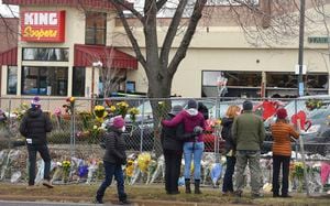 The flowers were growing by the hour on Tuesday, March 23, 2021. They were left by multitudes of mourners for the 10 people killed at the Boulder King Soopers in Boulder, Colo. on Monday. (Jerilee Bennett/The Gazette via AP)