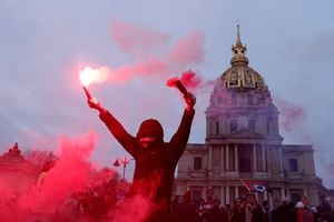 Manifestante sostiene bengalas rojas cerca de los Inválidos durante una manifestación contra el plan de reforma de pensiones del gobierno francés en París como parte de un día de huelga nacional y protestas en Francia, el 31 de enero de 2023. 