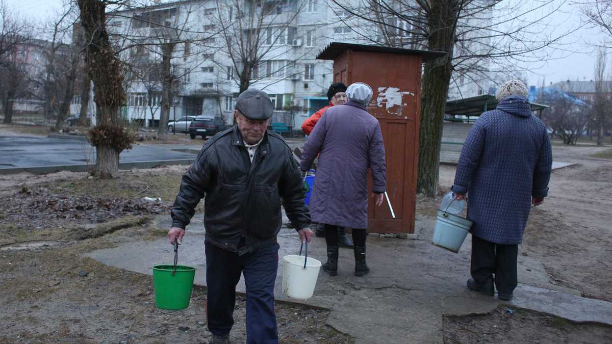Residentes recogen agua en Schastia, en la ciudad ucraniana de Lugansk, el 23 de febrero de 2022 (Photo by Anatolii Stepanov / AFP)