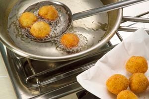 UNSPECIFIED - JANUARY 27: Rolled balls of mashed potatoes, marjoram, pine nuts, parmesan and egg yolk, fried in hot oil. Ligurian cuculli (fried mashed potato dumplings) step 4. (Photo by DeAgostini/Getty Images)