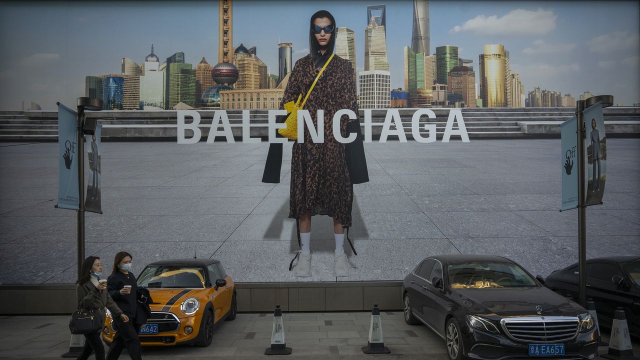 BEIJING, CHINA - OCTOBER 16: People walk in front of a Balenciaga ad on October 16, 2021 in Beijing, China. According to an action plan released on October 14, Beijing has unveiled a series of measures aimed at building the city into an international consumption center over the next five years. (Photo by Andrea Verdelli/Getty Images)