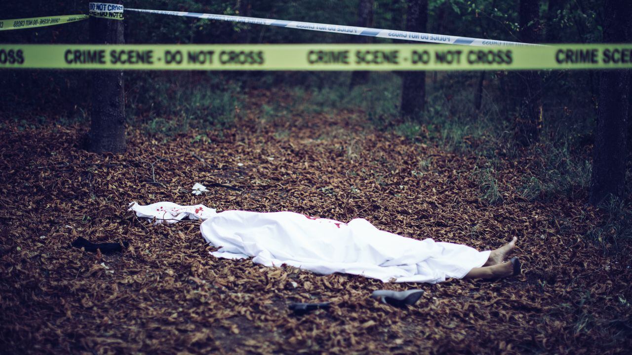 Cadáver cubierto con una sábana en la escena del crimen de asesinato
