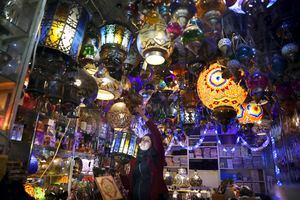 Una mujer palestina cuelga luces decorativas en preparación para el mes sagrado musulmán del Ramadán, en una tienda en la Ciudad Vieja de Jerusalén, el lunes 12 de abril de 2021. Foto: AP / Mahmoud Illean.