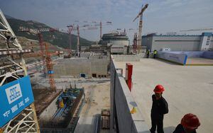 (FILES) This file photo taken on December 8, 2013 shows workers waiting for then-French Prime Minister Jean-Marc Ayrault to arrive at the joint Sino-French Taishan Nuclear Power Station outside the city of Taishan in Guangdong province. - French nuclear firm Framatome said on June 14, 2021 it was working to resolve a "performance issue" at the plant it part-owns in China's southern Guangdong province following a US media report of a potential leak there. (Photo by PETER PARKS / AFP)