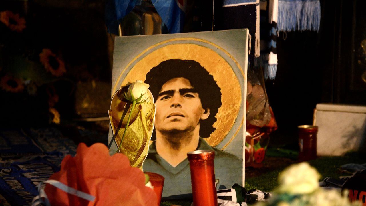 A picture of late Argentinian soccer player Diego Armando Maradona is displayed among flowers in the Spanish district of Naples on November 25, 2021. - Naples is paying tribute to Diego Maradona on the first anniversary of his death with three statues, two to be set up in the recently renamed Diego Armando Maradona football stadium and one already sitting in the city's National Archaeological Museum. (Photo by Filippo MONTEFORTE / AFP)