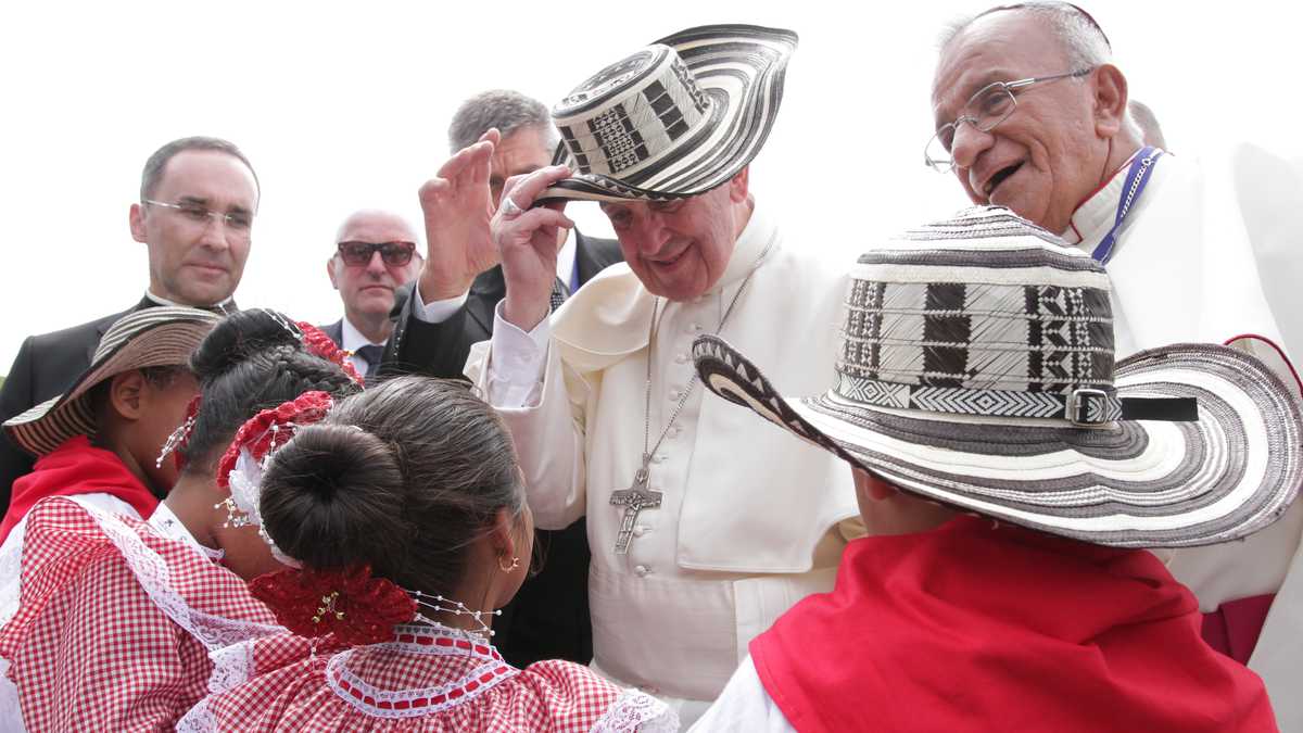 El papa Francisco se prueba el sombrero vueltiao que le obsequiaron las niñas y niños que lo esperaban en el aeropuerto de Cartagena.