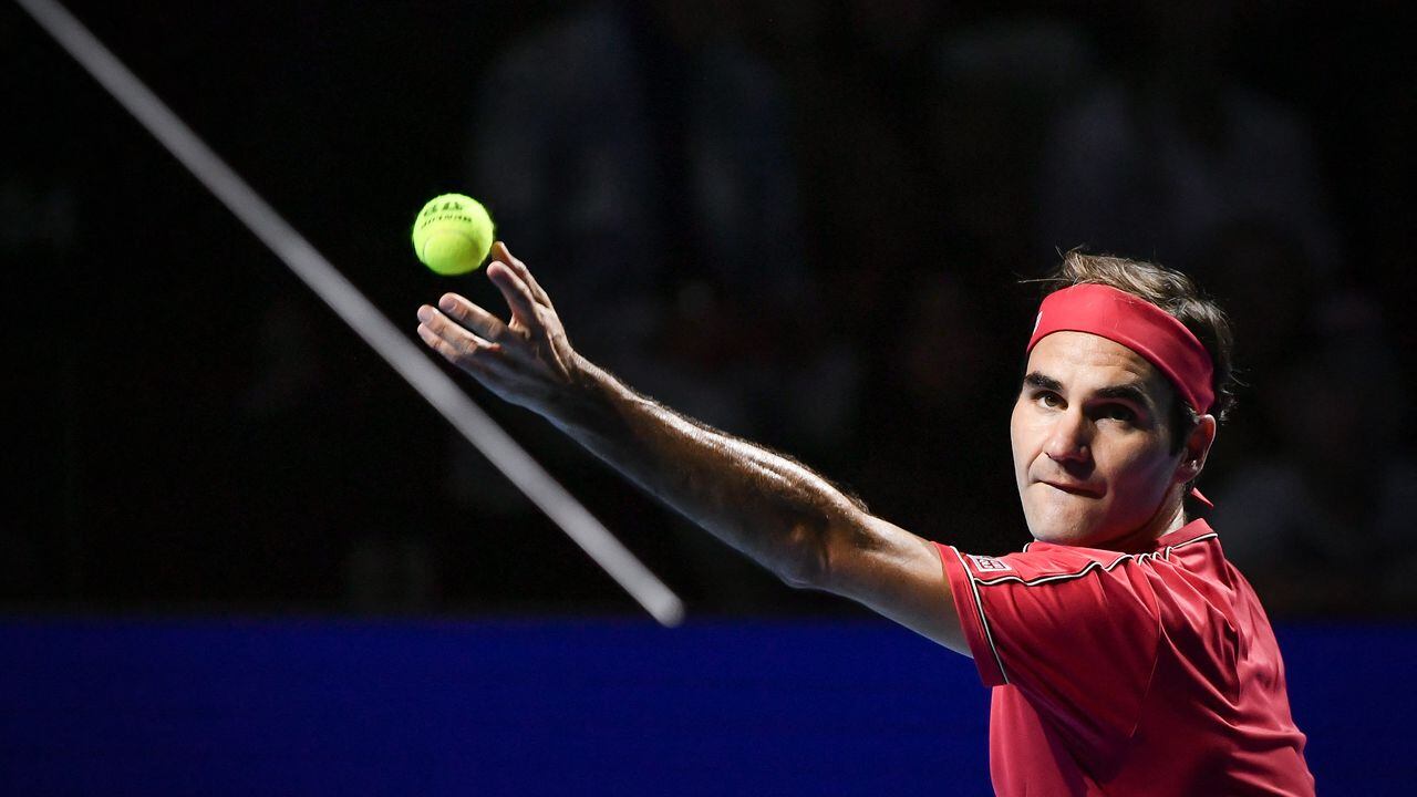 (FILES) In this file photo taken on October 27, 2019 Swiss Roger Federer serves a ball to Australian Alex De Minaur during their final match at the Swiss Indoors tennis tournament in Basel. - Former men's tennis world number one Roger Federer, plagued by recurring knee problems for the last two years, is to return to the ATP circuit at the Basel indoor tournament in October, organisers announced on April 26, 2022. (Photo by FABRICE COFFRINI / AFP)