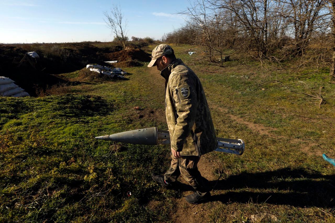 Un miembro de las Fuerzas Especiales de Ucrania, cuyas llamadas se identifican en Banderas, sostiene un casete de misiles rusos que llevaba bombas de racimo.