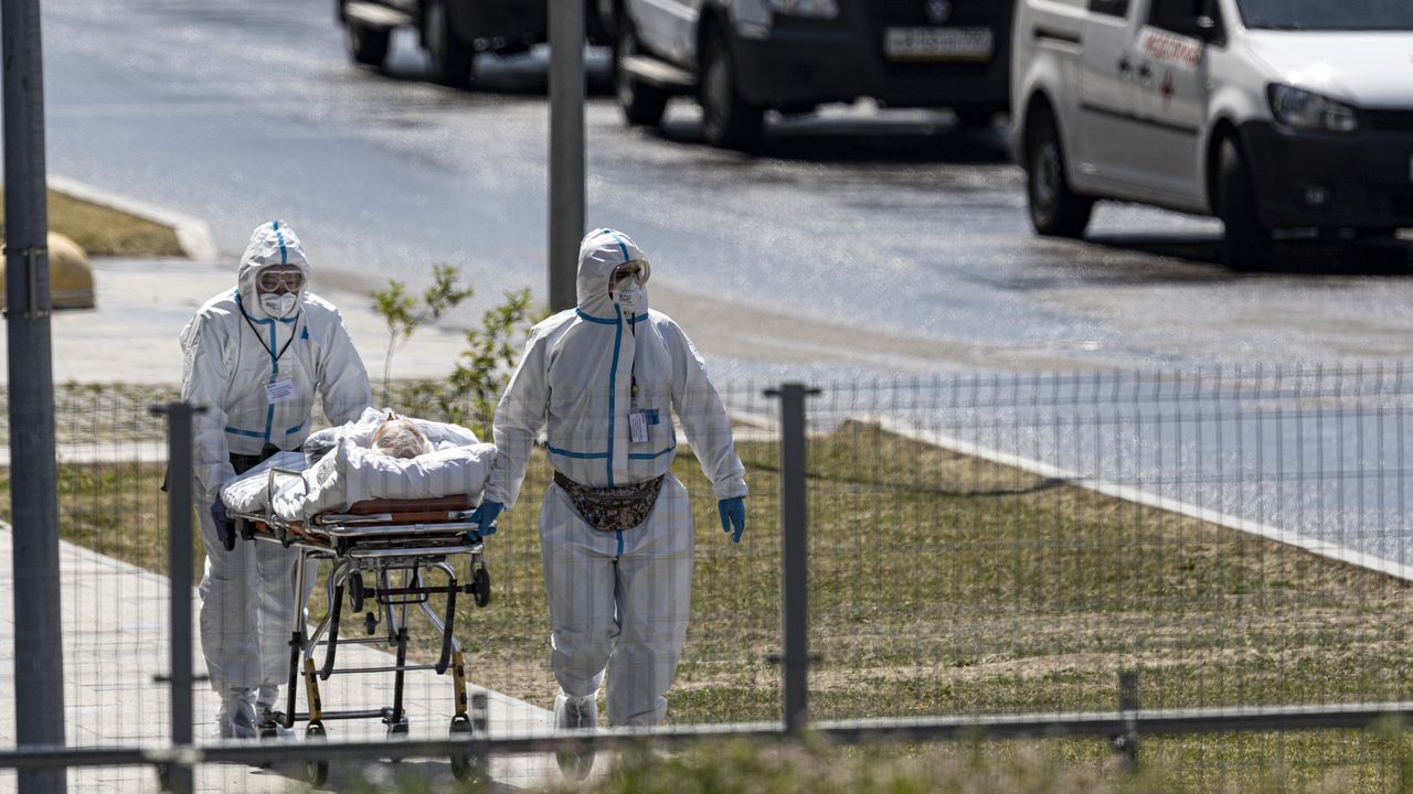 Trabajadores médicos llevan en una camilla a un paciente sospechoso de tener virus a un hospital en Kommunarka, en las afueras de Moscú, ciudad altamente afectada por la variante Delta del coronavirus. (AP Foto / Alexander Zemlianichenko)