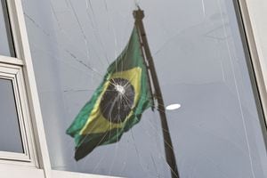 La bandera de Brasil se refleja en una ventana rota, después de que los partidarios del ex presidente de Brasil, Jair Bolsonaro, participaran en un motín antidemocrático en el Palacio de Planalto, en Brasilia, Brasil, el 9 de enero de 2023. 