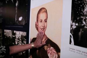 Una mujer toca la foto de Eva Perón exhibida en el museo que hay en Los Toldos, Argentina. Foto: Natacha Pisarenko
