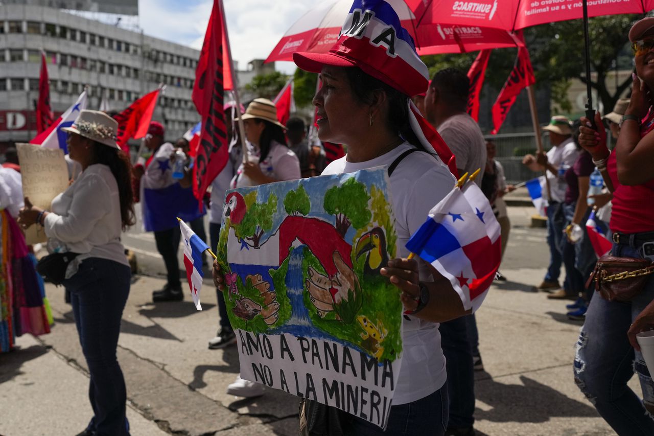 Una mujer sostiene una pancarta con un mensaje que dice en español: "Amo Panamá, no la minería", durante una protesta contra un contrato minero entre el gobierno panameño y la minera canadiense First Quantum, en Ciudad de Panamá, el viernes 3 de noviembre