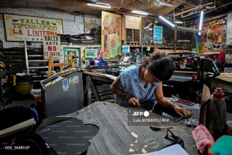 Olmedo Franco, 62, prints posters in a 1890 New York�s Reliance printing press, inside the La Linterna printing house in Cali, Colombia, on March 2, 2021. - In the heart of the colonial district of Cali, the La Linterna printing house was slowly dying out until graphic designers and street artists rekindled this beacon of traditional typography. (Photo by Luis ROBAYO / AFP)