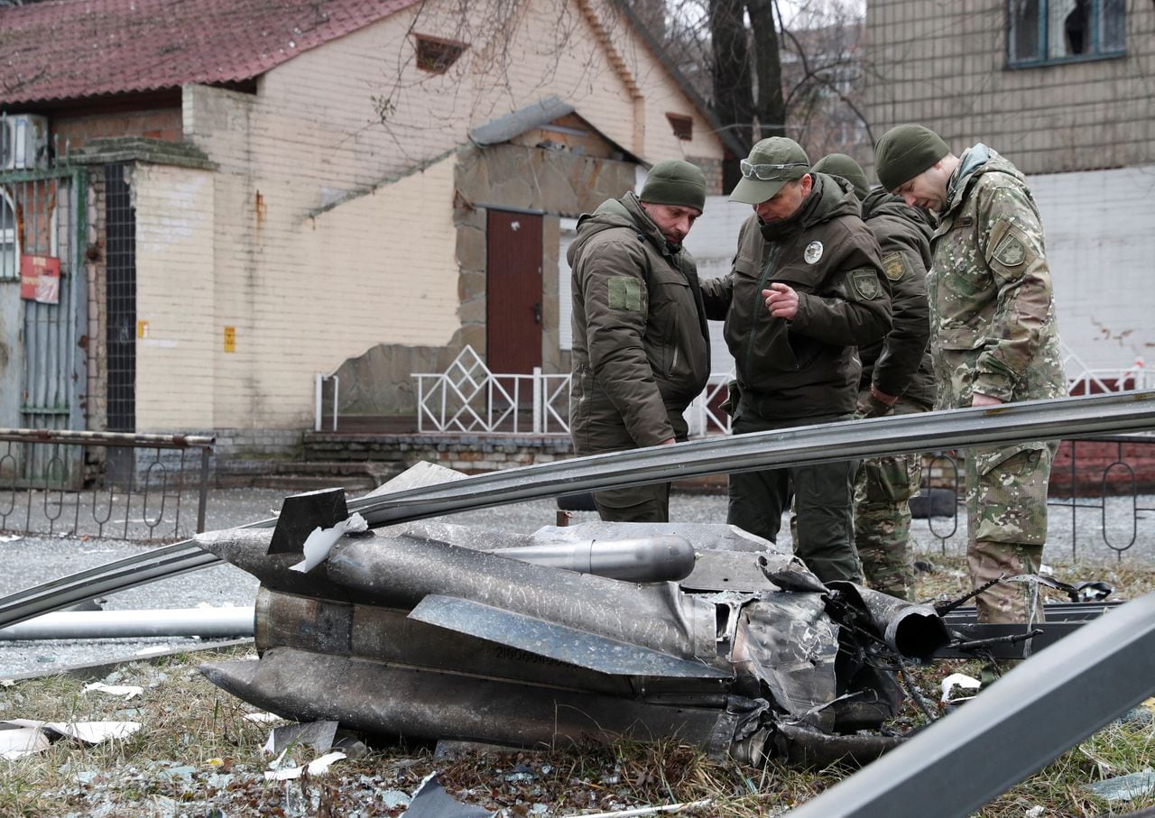 Agentes de policía inspeccionan los restos de un misil que cayó en la calle en Kiev.