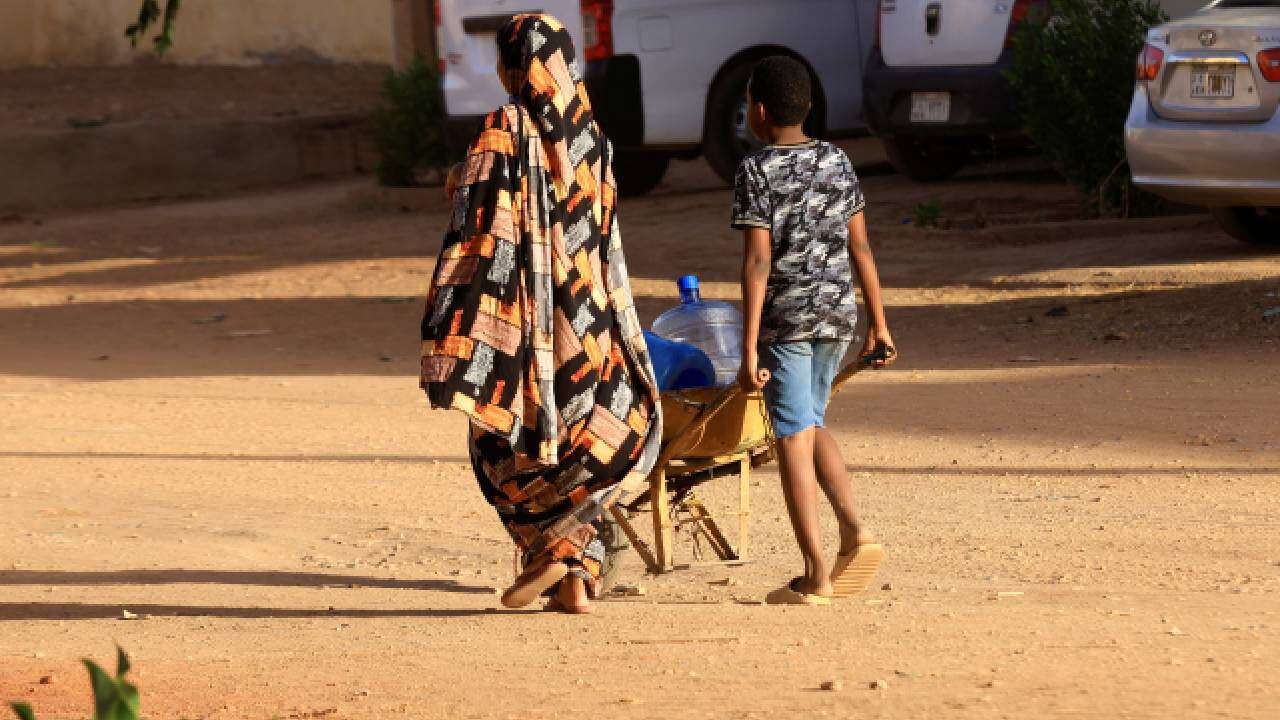 Sudaneses buscan agua durante los enfrentamientos entre las Fuerzas de Apoyo Rápido paramilitares y el ejército en Jartum Norte.