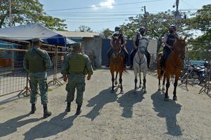 Soldiers and mounted policemen stand guard outside a prison in Guayaquil, Ecuador, on September 29, 2021, after a riot occurred. - Thirty prisoners were killed and 47 wounded in a battle between armed inmates aligned to rival gangs at a jail in Ecuador's largest city Tuesday, officials said. (Photo by Fernando MENDEZ / AFP)