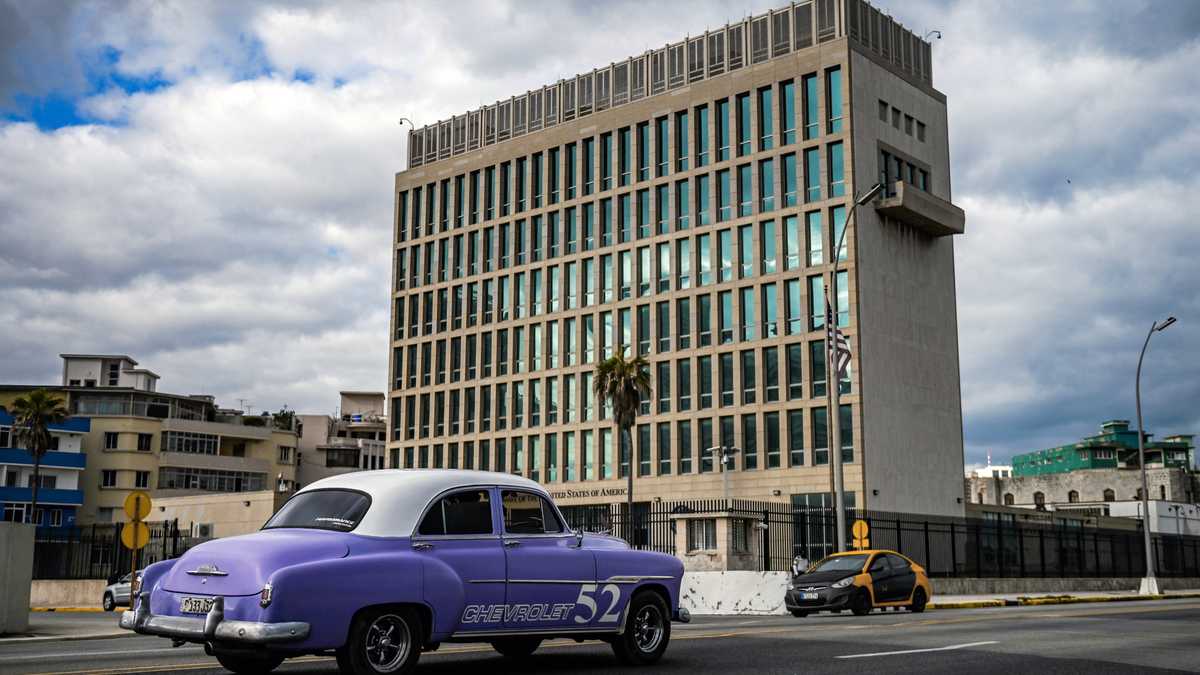 Un viejo automóvil estadounidense pasa frente a la embajada de EE. UU. en La Habana el 3 de mayo de 2022, cuando el consulado reanudó la emisión de algunos servicios de visas de inmigrantes que han estado suspendidos desde 2017 luego de supuestos "ataques sónicos".