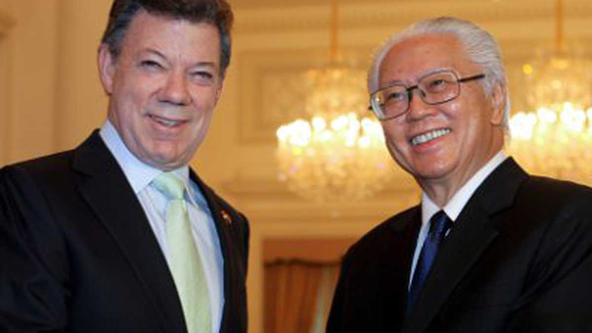 El presidente singapurense, Tony Tan (derecha), da la bienvenida a su homólogo Juan Manuel Santos (izquierda), antes de la reunión mantenida en el Palacio Presidencial en Singapur.