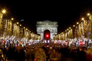La gente asiste a la inauguración de las luces navideñas a lo largo de los Campos Elíseos con el Arco del Triunfo al fondo, en París, Francia