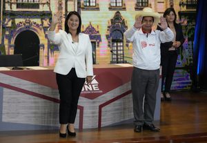 Peruvian presidential candidates, right-wing Keiko Fujimori (L) and socialist Pedro Castillo, wave at the end of the final televised debate in Arequipa on May 30, 2021, ahead of a runoff election on June 6. (Photo by Martin Mejia / POOL / AFP)